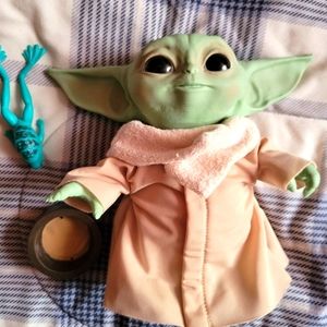 Baby Yoda with cup and frog.